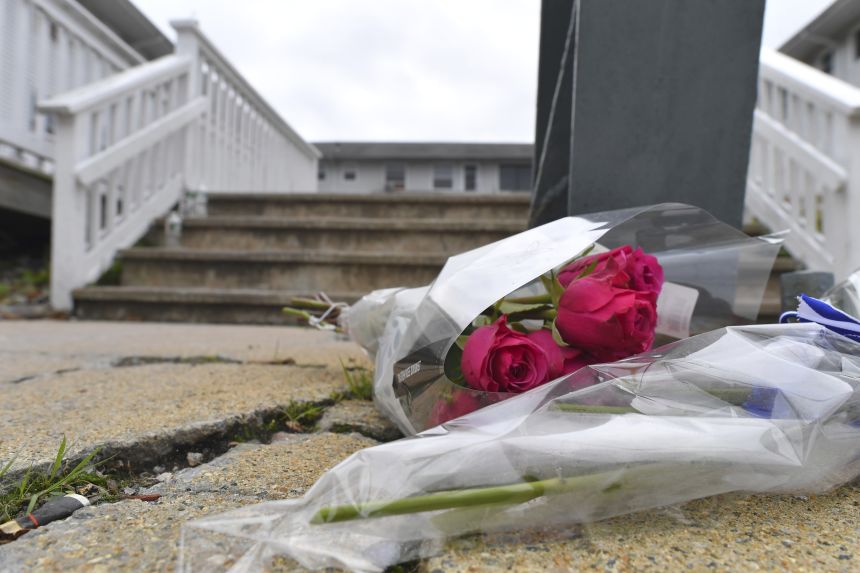 Flowers rest near an entrance to the Gabriel House assisted living facility following a fire that started late Sunday and resulted in multiple fatalities.