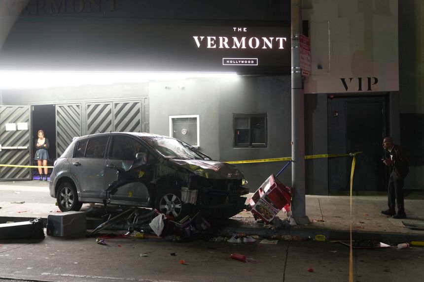 A vehicle sits on the sidewalk after ramming into a crowd of people waiting to enter a nightclub along a busy boulevard in Los Angeles early Saturday, injuring several people.