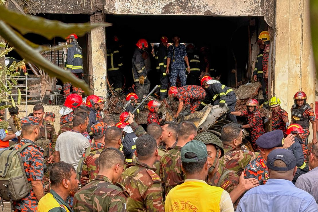 Firemen check the wreckage of a Bangladesh Air Force training aircraft that crashed onto a school campus in Dhaka.