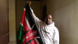 Prominent Kenyan activist Boniface Mwangi poses for a photo while holding a Kenyan flag inside the dock at Kahawa Law Courts in Kiambu, Kenya, Monday, July 21, 2025. (AP Photo/Brian Inganga)
