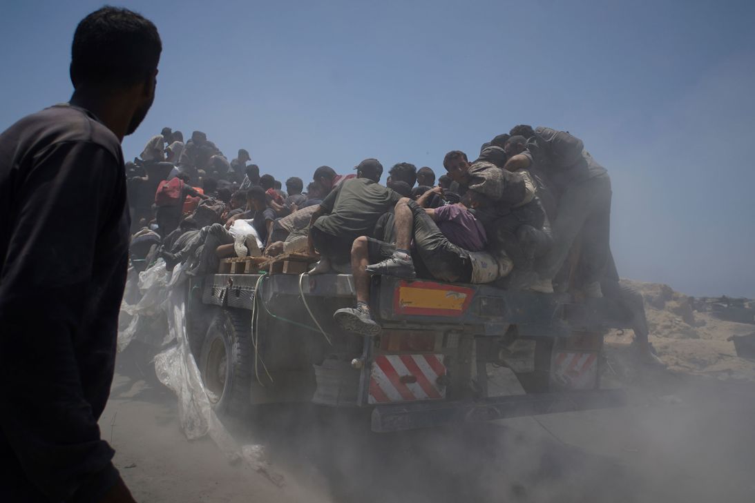 Palestinians hold onto an aid truck returning to Gaza City on July 22.