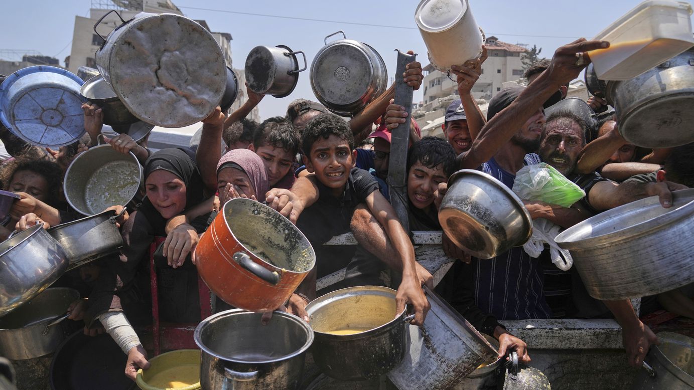 Palestinians struggle to get food at a community kitchen in Gaza City on  Saturday, July 26, 2025.