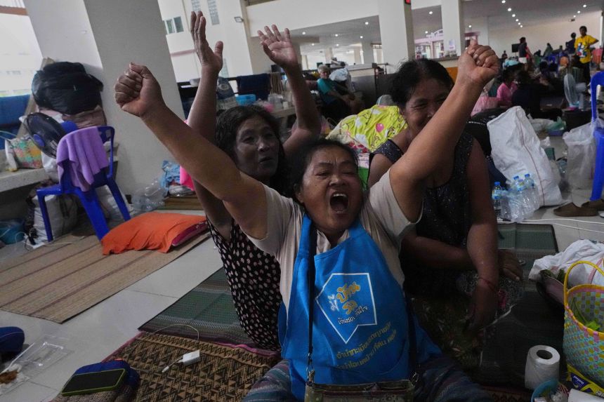 Thai residents who fled their homes following the cross-border clashes celebrate at an evacuation center in Surin province, Thailand, after hearing the announcement of an immediate and unconditional ceasefire on Monday.