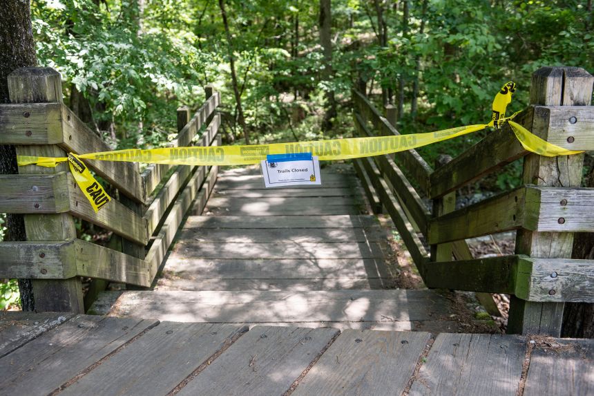 The trail head to the Devil's Den trail at Devil's Den State Park was closed Monday as police searched for a murder suspect.