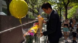A person leaves flowers at a makeshift memorial Tuesday outside the building in Manhattan where the shooting took place.