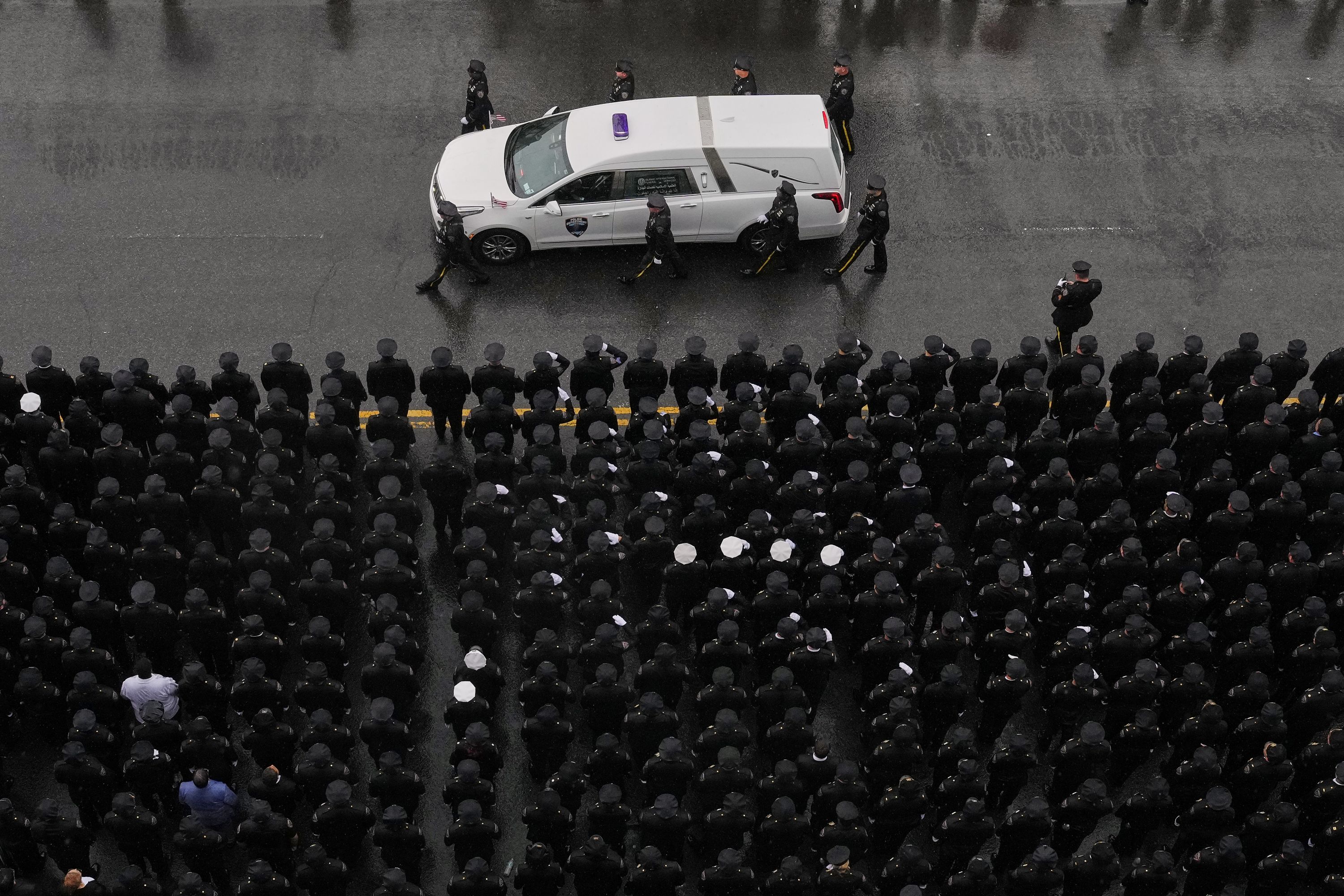 New York police officers salute a hearse after the funeral of fellow officer Didarul Islam on Thursday, July 31.