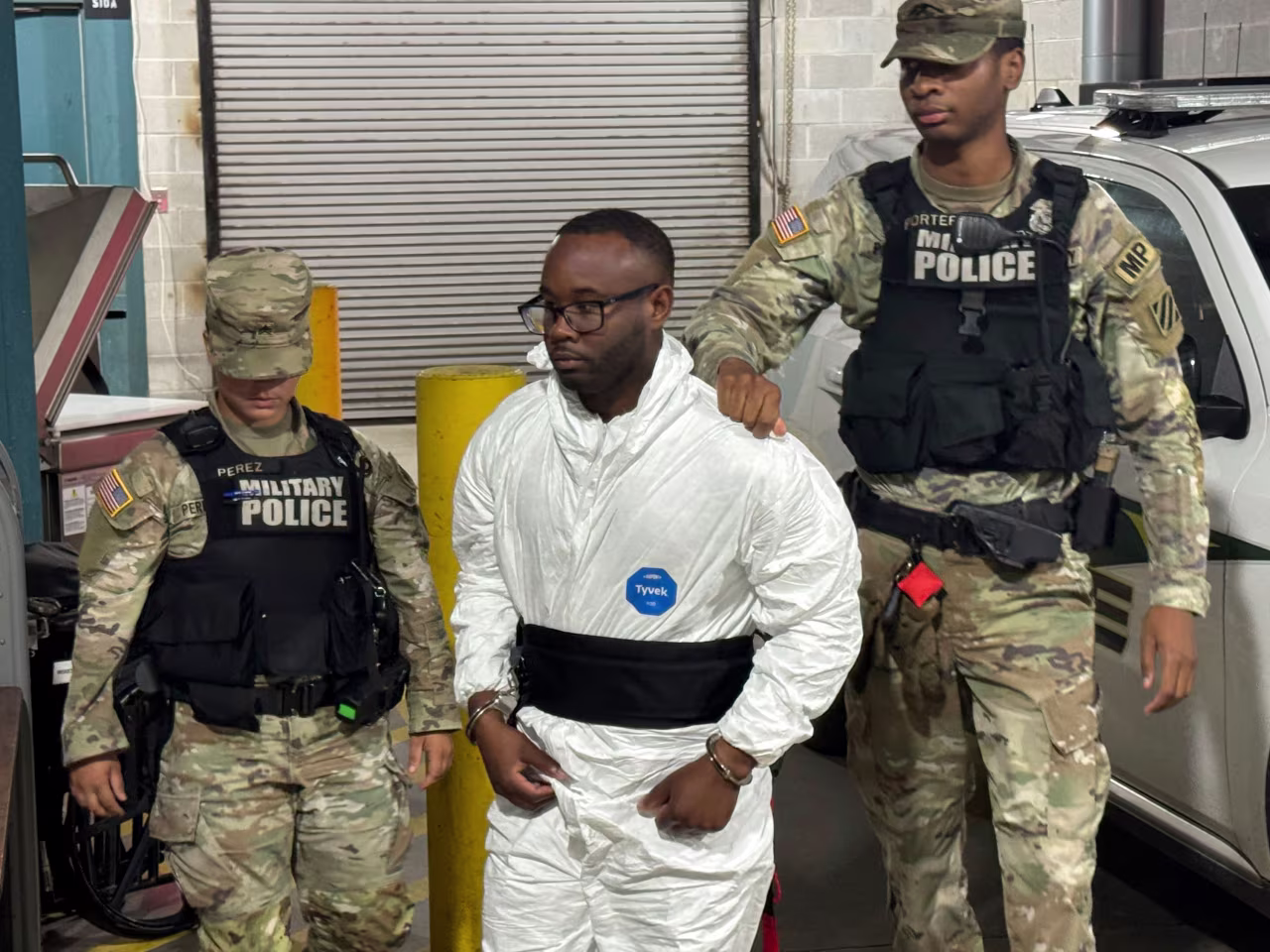 Sgt. Quornelius Radford is escorted by military police into a booking room at the Liberty County Jail in Hinesville, Georgia, on Wednesday.
