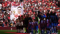 Liverpool and Crystal Palace players line up ahead of kick off as fans display a banner in memory of Liverpool's Diogo Jota.