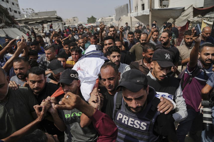 Palestinians carry the body of Al Jazeera reporter Anas Al-Sharif, who, along with other journalists, was killed in an Israeli airstrike, during his funeral outside Gaza City's Shifa hospital complex on August 11.