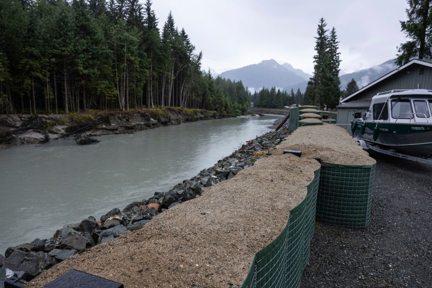 HESCO flood barriers, to protect property against glacial outburst flooding, separate a residential area from the Mendenhall River, on August 3, in Juneau, Alaska.