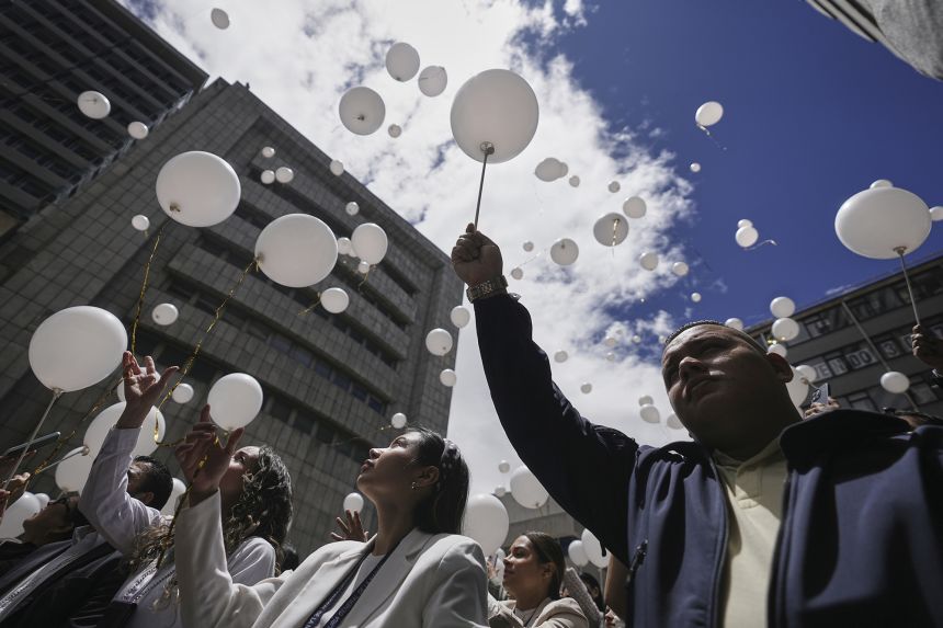 Employees of the attorney general's office release balloons during a ceremony to honor opposition Sen. Miguel Uribe, after his death more than two months after he was shot during a political rally, in Bogota, Colombia, Monday, Aug. 11, 2025.