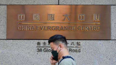 A man walks past the entrance of the headquarters of China Evergrande Group in Hong Kong Monday, Oct. 4, 2021.