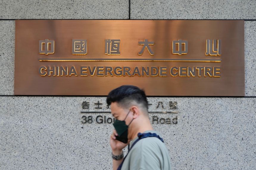 A man walks past the entrance of the headquarters of China Evergrande Group in Hong Kong on October 4, 2021.
