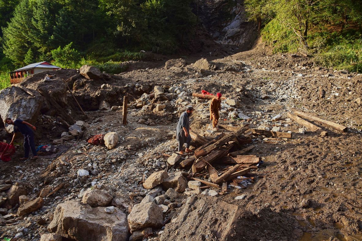 Villagers sift through debris from homes damaged in a flash flood in Pakistan-administered Kashmir on August 15.