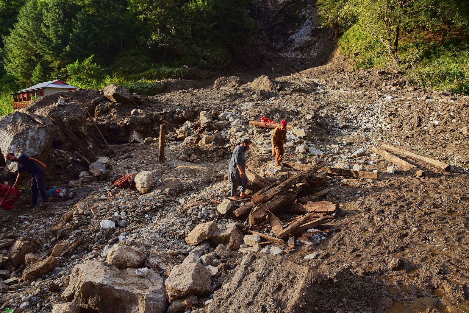 Villagers sift through debris from homes damaged in a flash flood in Pakistan-administered Kashmir on August 15.