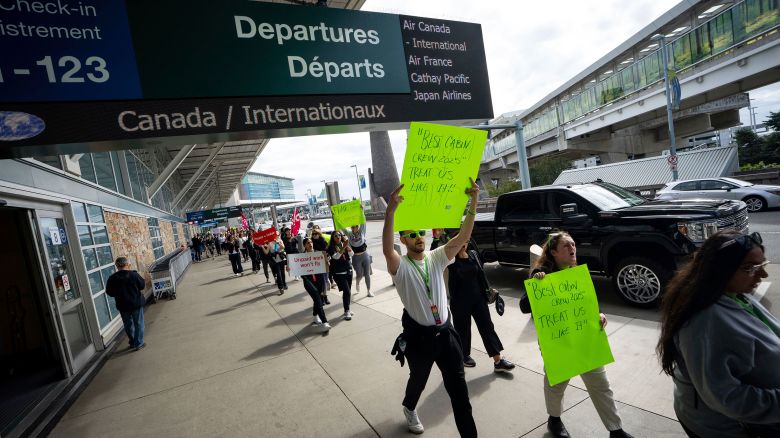 Picketers march around the departures level at the Vancouver International Airport in Richmond, British Columbia, on Sunday, August 17, 2025.