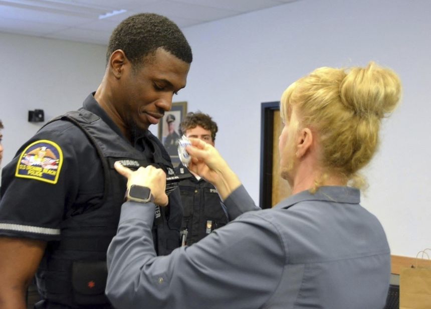 Officer Jon Luke Evans receives his police badge. He served as a reserve officer for barely a month before being arrested by ICE and agreeing to voluntarily leave the US.