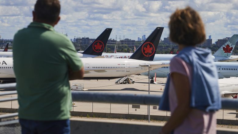 Travelers look out over grounded Air Canada planes as flight attendants picket at Pearson International Airport in Toronto on August 18, 2025.