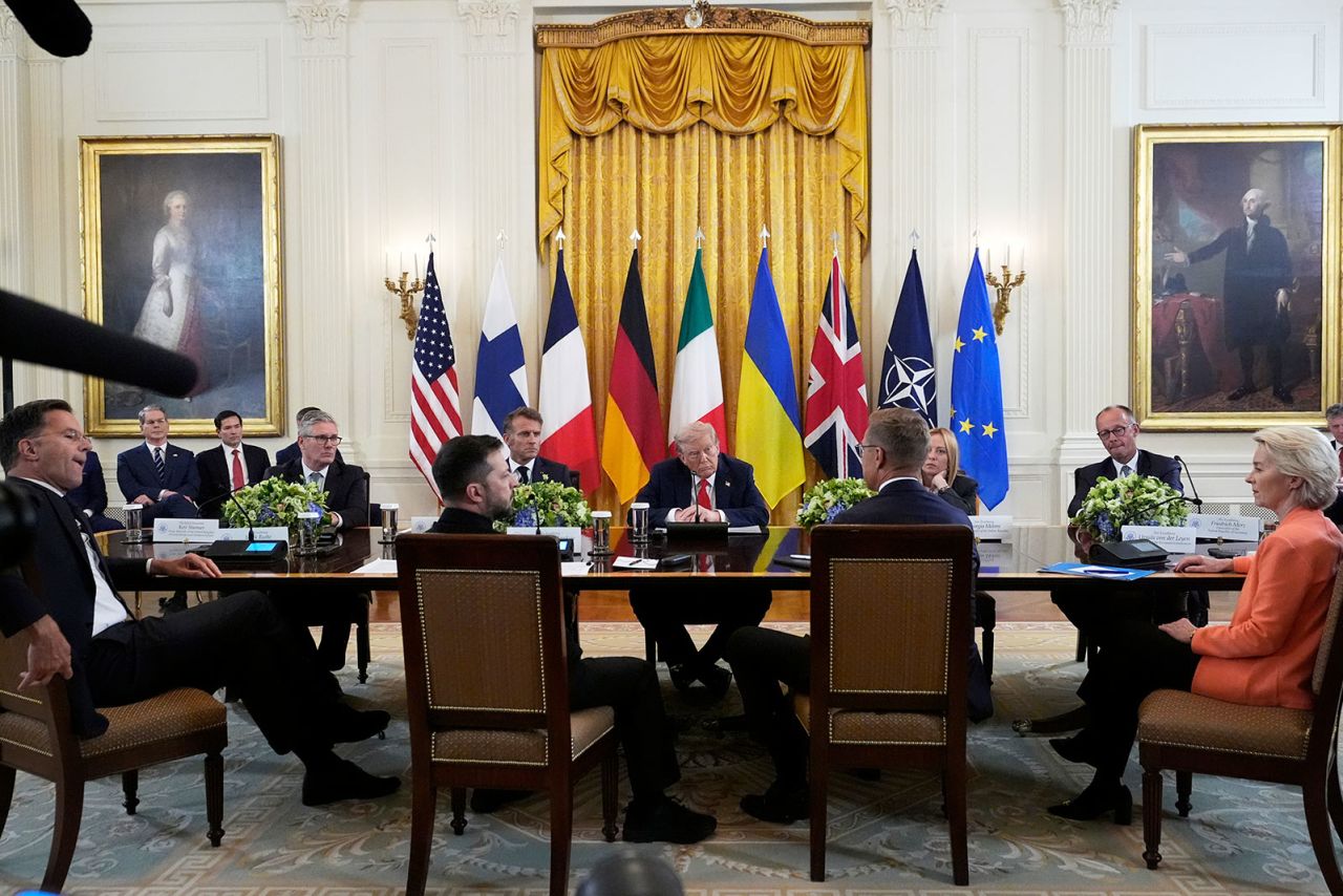 Төвийн ерөнхийлөгч Дональд Трамп Их Британийн Ерөнхий сайд Кейр Стармер, зүүн төвөөс ширээний ард сууж буй Францын Ерөнхийлөгч Эммануэль Макрон, Италийн Ерөнхий сайд Жоржиа Мелони, Германы Канцлер Фридрих Мерц, зүүн талаас НАТО-гийн Ерөнхий нарийн бичгийн дарга Марк Рютте, Украины Ерөнхийлөгч Владимир Зеленский, Финляндын Ерөнхийлөгч Владимир Зеленский, Финляндын Ерөнхийлөгч Алье Стубббс нартай уулзалтад оролцож байна. Лейен, Сангийн сайд Скотт Бессент, зүүн гар талаас Төрийн нарийн бичгийн дарга Марко Рубио нар даваа гарагт Цагаан ордны зүүн танхимд сонсож байна.