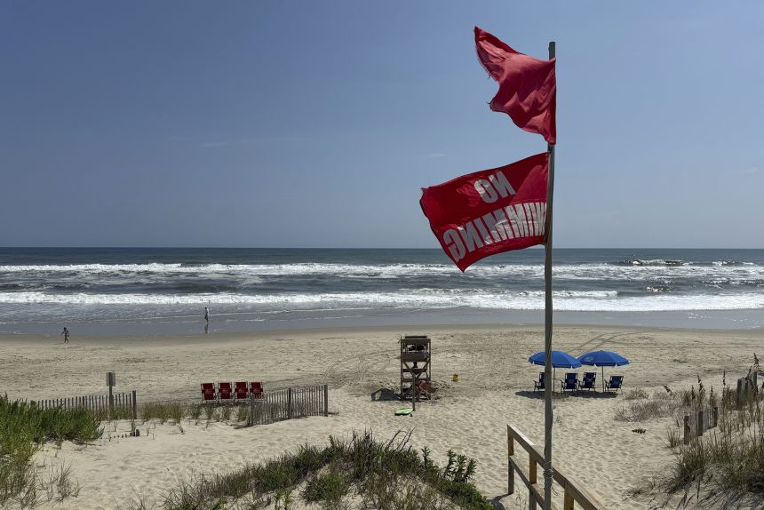 Red flags, indicating swimming is prohibited, are raised at the beach in Duck, North Carolina, on Tuesday, Aug. 19, 2025, as precautions are taken ahead of Hurricane Erin.