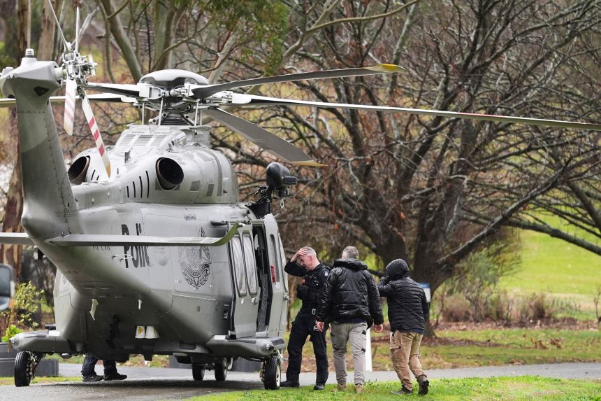 Police board a helicopter at a command area at Feathertop Winery in Porepunkah in Victoria, Australia, Wednesday, Aug. 27, 2025.