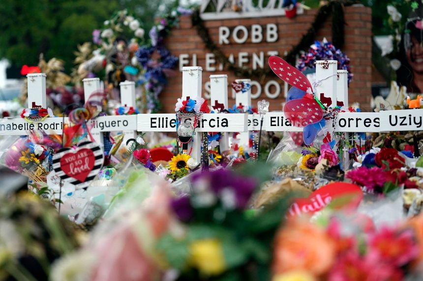 Crosses are surrounded by flowers and other mementos at a memorial for the victims of a shooting at Robb Elementary School in Uvalde, Texas, on June 9, 2022.