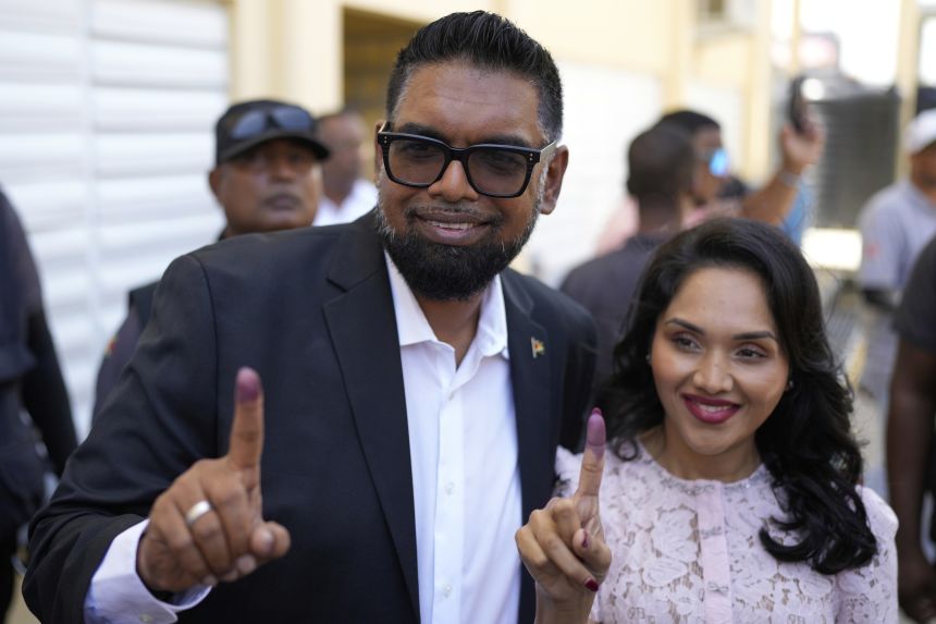 Wanting another term, President Irfan Ali and his wife Alia Ali will show their ink fingers after voting in the general election in Leonora, Guyana on Monday.