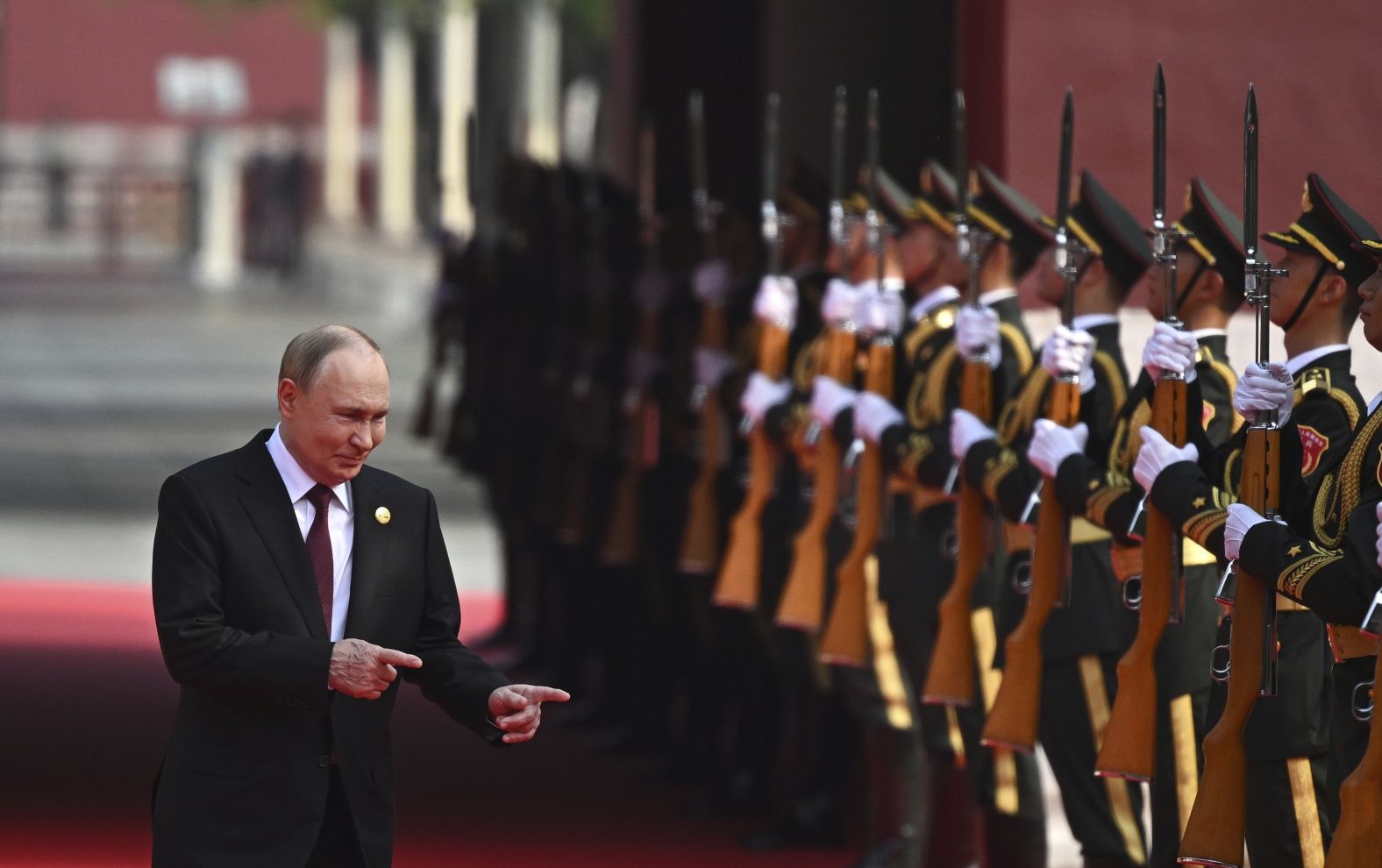 Vladimir Putin gestures as he arrives for the parade.