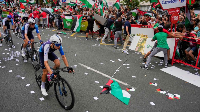 Riders of the Israel-Premier Tech team compete as people holding Palestinian flags try to disrupt the 11th stage of the Spanish Vuelta cycling race, from Bilbao to Bilbao, Spain, on September 3.