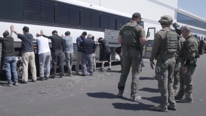 This image from video provided by U.S. Immigration and Customs Enforcement via DVIDS shows manufacturing plant employees waiting to have their legs shackled at the Hyundai Motor Group’s electric vehicle plant, in Ellabell, Georgia, on September 4, 2025.