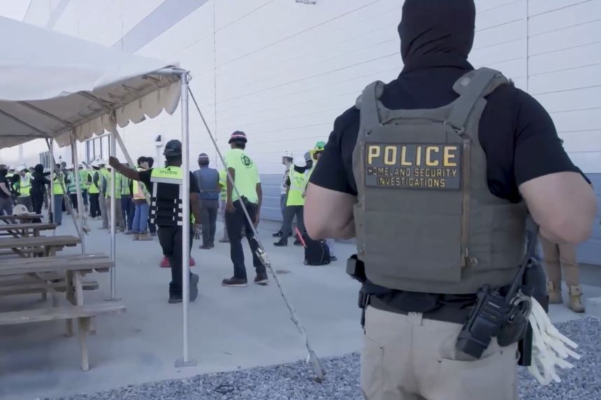 This image from video provided by US Immigration and Customs Enforcement via DVIDS shows manufacturing plant employees being escorted outside the Hyundai Motor Group’s electric vehicle plant on September 4, in Ellabell, Georgia.