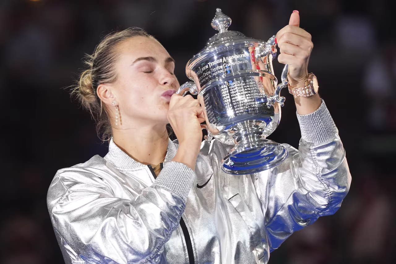 Aryna Sabalenka kisses the championship trophy.