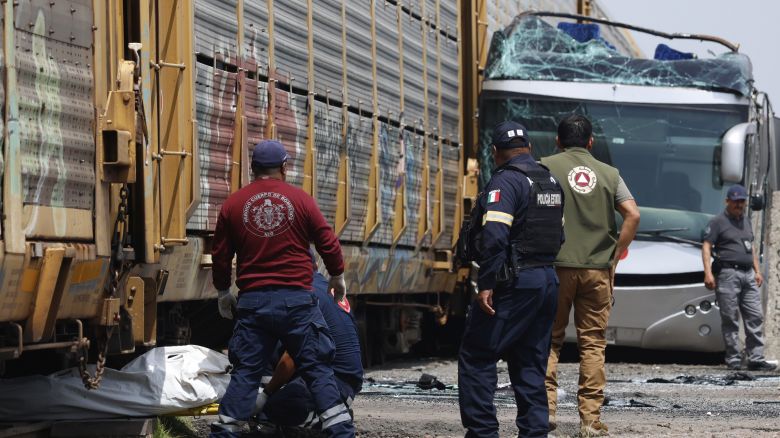 Rescue workers remove a body at the scene of a deadly accident where a freight train slammed into a double-deck bus in Atlacomulco, Mexico, Monday, Sept. 8, 2025.