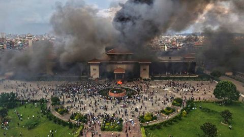 Protesters celebrate at the Singha Durbar, the seat of Nepal's government's various ministries and offices after it was set on fire during a protest against social media ban and corruption in Kathmandu, Nepal on September 9, 2025.