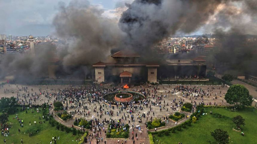 Protesters celebrate at the Singha Durbar, the seat of Nepal's government offices after it was set on fire during a protest in Kathmandu on Tuesday.