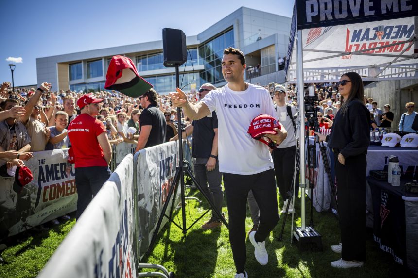 Charlie Kirk hands out hats before speaking at Utah Valley University on Wednesday.