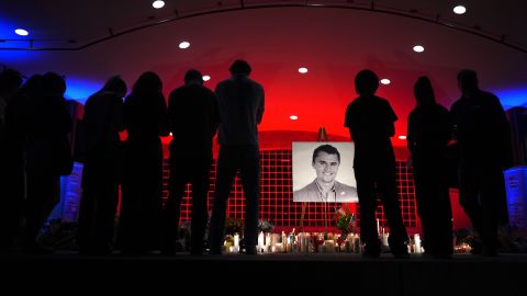 People look at a photo of Charlie Kirk, the CEO and co-founder of Turning Point USA who was shot and killed, at a vigil in his memory, Thursday, Sept. 11, 2025, in Orem, Utah.