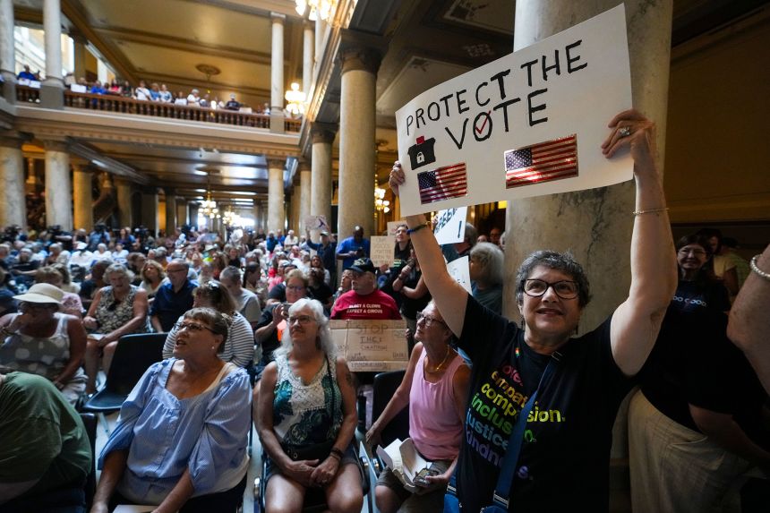 Annette Groos holds a sign before the start of a rally for Indiana Democrats amid pressure from President Donald Trump for Republicans to redistrict congressional seats.