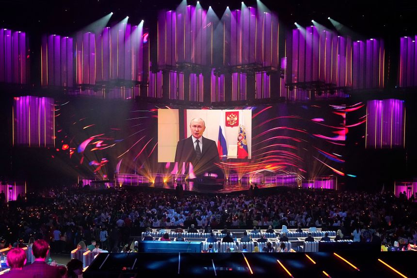Russian President Vladimir Putin addresses participants and spectators of