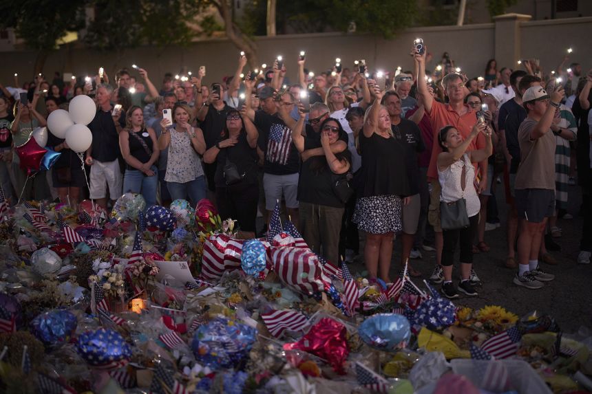 People visit a makeshift memorial for Charlie Kirk outside Turning Point USA headquarters on September 20 in Phoenix, Arizona.