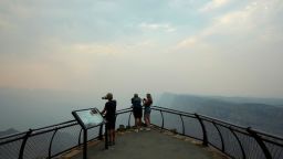 Smoke from the Dragon Bravo Fire moves over the Grand Canyon from the North Rim blocking the view for tourists at the Desert View overlook, in Grand Canyon National Park, on July 14, 2025.