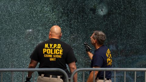 FILE - Members of the NYPD's Crime Scene Unit examine a door with bullet holes, Tuesday, July 29, 2025, in New York, the day after a deadly shooting. (AP Photo/Yuki Iwamura, File)
