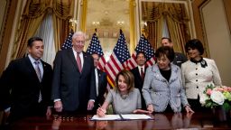 House Speaker Nancy Pelosi, accompanied by from left, Rep. Ben Ray Lujan, House Majority Leader Steny Hoyer, Rep. Nita Lowey, Rep. Lucille Roybal-Allard, and others, signs a deal to reopen the government on Capitol Hill in Washington, DC, January 25, 2019, after a record 35-day government shutdown.