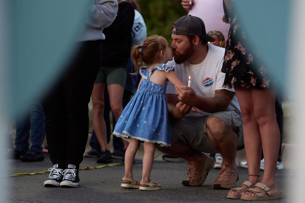 A father kisses his daughter during a vigil held for those impacted by the attack on The Church of Jesus Christ of Latter-day Saints in Grand Blanc Township, Michigan, on Tuesday.