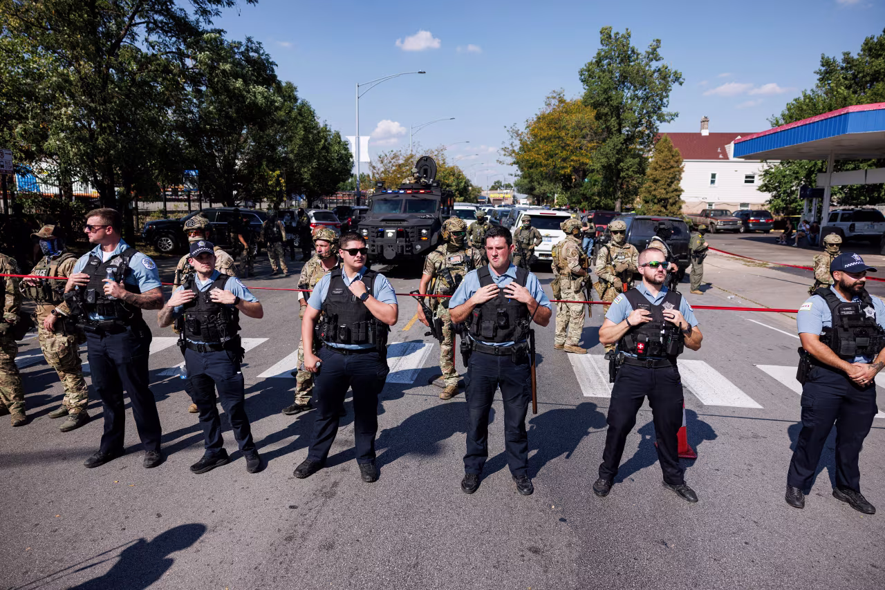 CPD officers stand in front of federal officers in the Brighton Park neighborhood of Chicago, on October 4, after protesters learned federal officers shot a woman Saturday morning.
