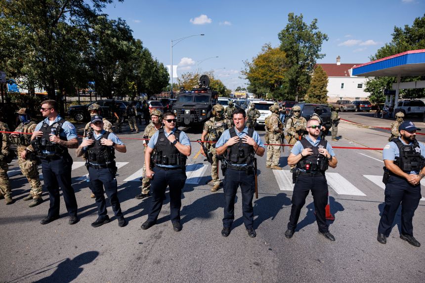 CPD officers stand in front of federal officers in the Brighton Park neighborhood of Chicago, on Saturday, Oct. 4, 2025, after protesters learned federal officers shot a woman Saturday morning.