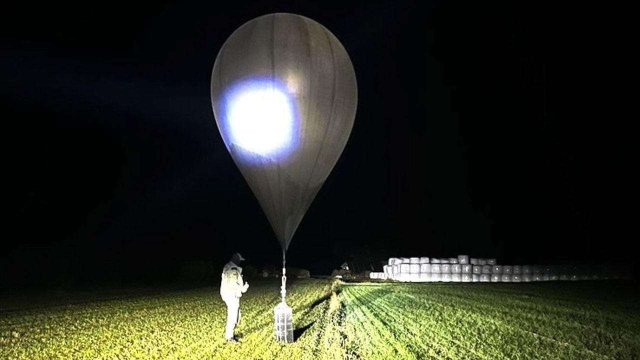 In this undated photo released by the State Border Guard Service, an officer inspects a balloon used to carry cigarettes into Lithuania, because Belarussian smugglers often use them to ferry the contraband into the European Union.