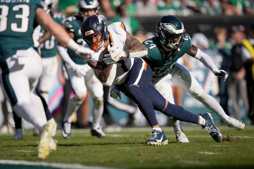 Denver Broncos tight end Evan Engram scores a touchdown past Philadelphia Eagles safety Andrew Mukuba.