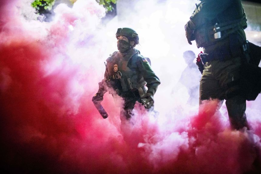 Police and federal officers throw gas canisters to disperse protesters near a US Immigration and Customs Enforcement facility in Portland on October 5, 2025.