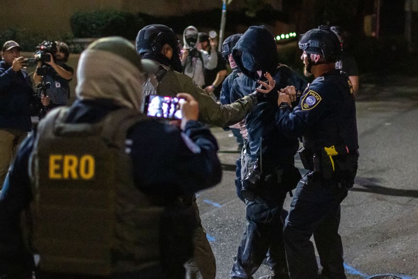 A protester is arrested by police and federal officers outside a US Immigration and Customs Enforcement facility in Portland, Oregon, on Monday.